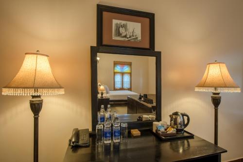 a vanity with two lamps and a mirror at Golden Tulip Stone Town Boutique in Zanzibar City