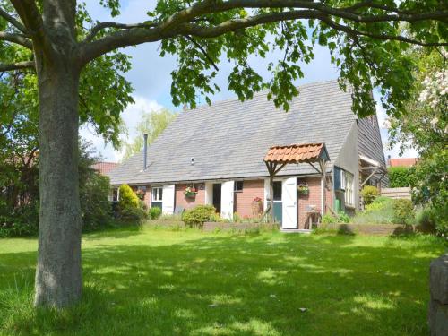 a house with a gray roof and a green yard at Cozy Holiday Home in Bergen op Zoom with Garden in Bergen op Zoom