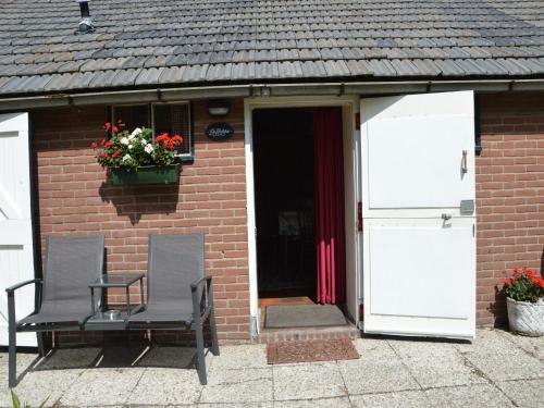 two chairs in front of a brick house with a door at Cozy Holiday Home in Bergen op Zoom with Garden in Bergen op Zoom