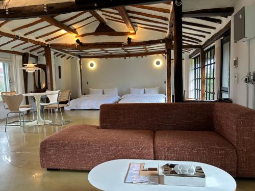 a living room with a couch and a bed at Imjingotaek Hanok Stay Jeju Traditional House LP Cozy House, Wagon stay at Imjingotaek in Jeju