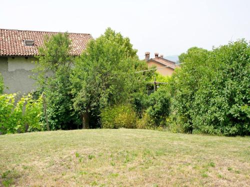 a yard with trees and a house in the background at Holiday home in Asti with a lovely hill view from the garden in Moncucco Torinese