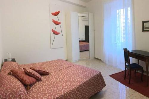 a bedroom with a bed with red pillows and a table at EnzHouse in Rome