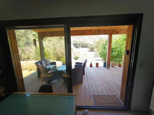 Una puerta abierta a un patio con mesa y sillas. en T3 en rez de villa sur les hauteurs d'Ajaccio, en Ajaccio
