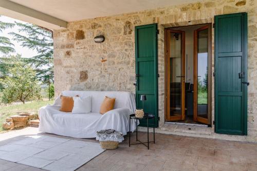 a bed on a patio with green doors at Italian Experience- Poggio Padule in San Venanzo