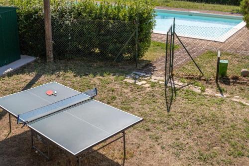 a ping pong table with a ball on it next to a pool at Italian Experience- Poggio Padule in San Venanzo