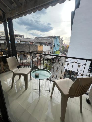 a balcony with chairs and a table and a view of a city at La Locanda in Bangkok