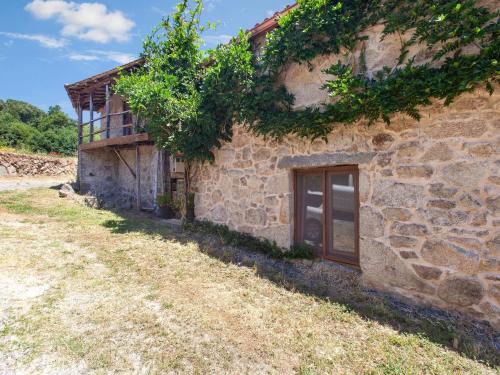 an old stone house with a door and a window at Traditional Apartment in Ribeira Sacra with Garden in Castillón
