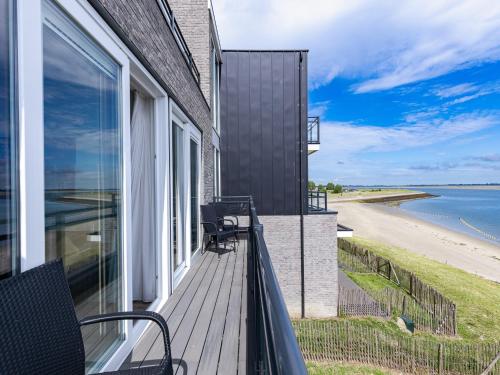 a balcony of a house with a view of the ocean at Unique apartment, located on the Oosterschelde and marina of Sint Annaland in Sint Annaland