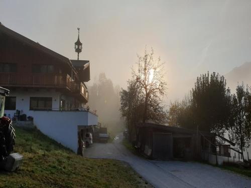 a foggy street with a building and the sun in the background at Apartment in Piesendorf near Ski Slopes in Piesendorf