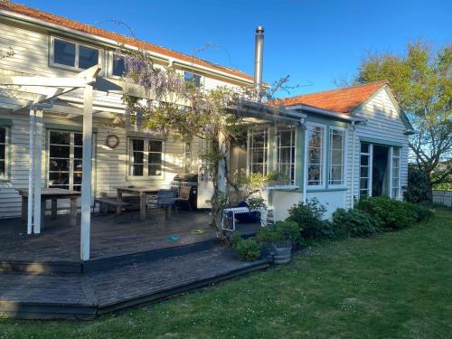 a white house with a deck and a table at Elegant Charming Family Villa in Greytown