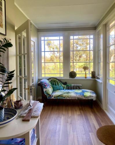 a living room with a couch and windows at Elegant Charming Family Villa in Greytown
