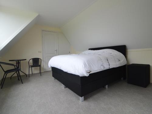 a bedroom with a bed and a table and chairs at Holiday Home in Holten near Lake IJssel in Holten