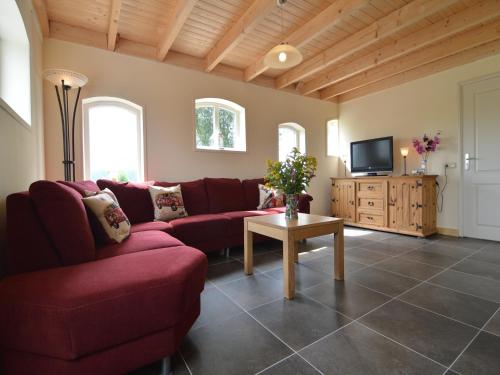 a living room with a red couch and a tv at Holiday Home in Holten near Lake IJssel in Holten
