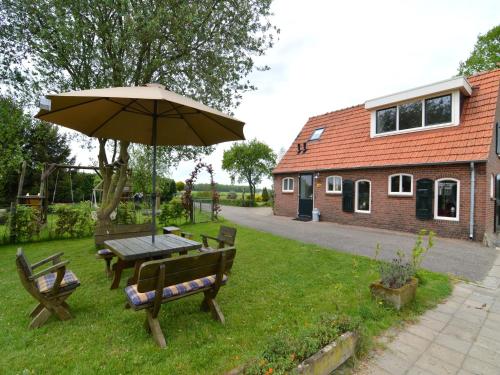a picnic table and an umbrella in a yard at Holiday Home in Holten near Lake IJssel in Holten