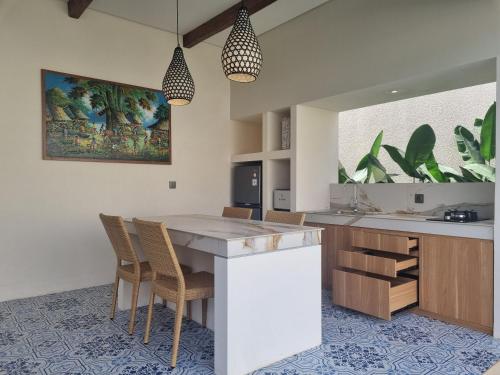 een keuken met een tafel en stoelen in een kamer bij Agusta Villas in Uluwatu