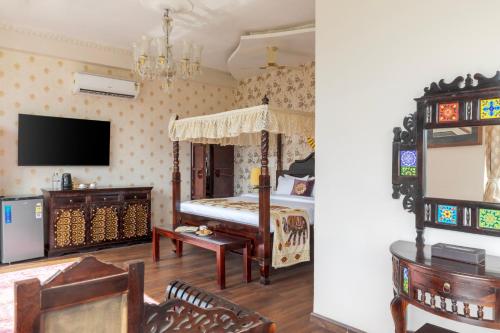 a bedroom with a bed and a tv on the wall at SaffronStays Raj Reverie in Jaipur