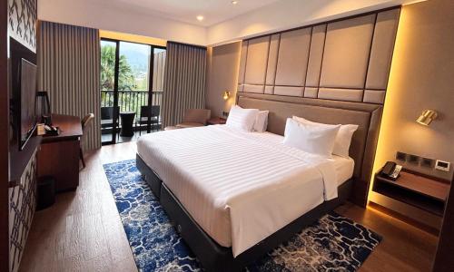 a bedroom with a large bed in a hotel room at Aston Sentul Lake Resort & Conference Center in Bogor