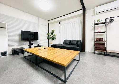 a living room with a wooden table and a couch at Alo BnB 10 - Near AKIHABARA, UENO, ASAKUSA, TOKYO SKY TREE - Self check-in in Tokyo