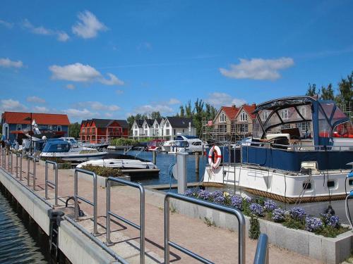 een groep boten aangemeerd in een jachthaven met huizen bij Apartment Hafenflair am Plauer See, Plau am See in Plau am See