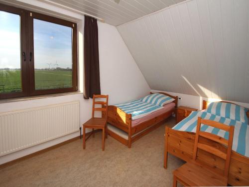 a room with two beds and a window at Geraeumige Ferienwohnungen mit eigener Terrasse, Neßmersiel in Neßmersiel