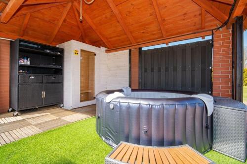 a hot tub in a backyard with a wooden roof at Holiday center with pool, Lacko in Łacko
