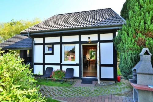 a small cottage with a black and white exterior at Holiday center with pool, Lacko in Łacko