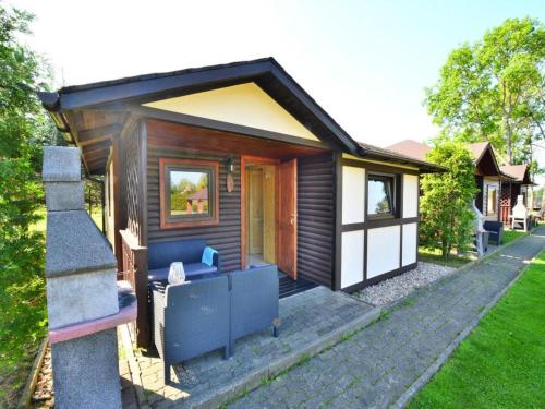 a small house with a blue couch in front of it at Holiday center with pool, Lacko in Łacko