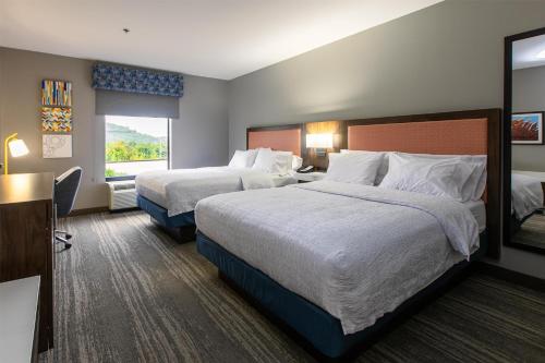 a hotel room with two beds and a window at Hampton Inn & Suites Wilder in Wilder