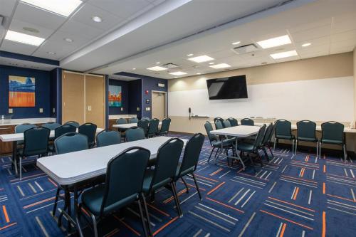 a conference room with tables and chairs and a screen at Hampton Inn & Suites Wilder in Wilder