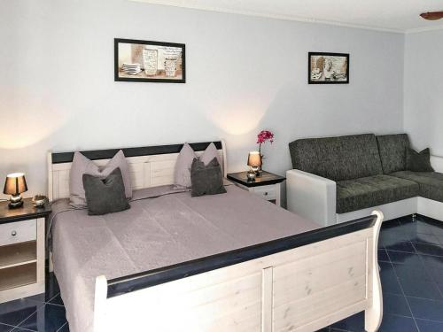 a bedroom with a large bed and a couch at Apartments with terrace at the Kummerower See in Sommersdorf in Sommersdorf