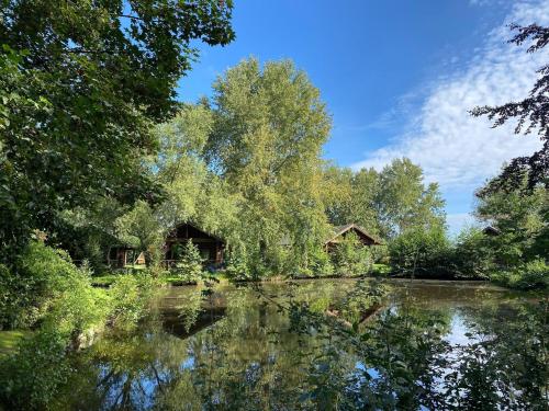 a house on a river with a reflection in the water at Ferienhaus in Hechthausen mit Terrasse in Hechthausen