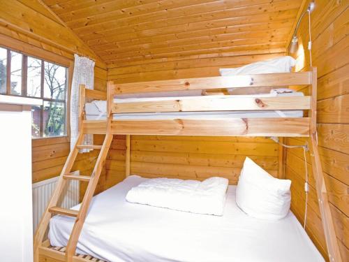 a bedroom with bunk beds in a wooden cabin at Ferienhaus in Hechthausen mit Terrasse in Hechthausen