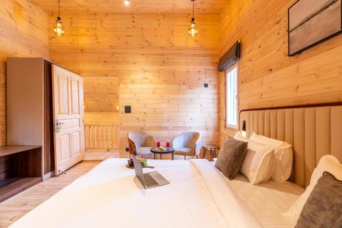 ein Schlafzimmer mit einem Bett in einer Holzhütte in der Unterkunft SaffronStays The Woods - Pine Villa in Dehradun