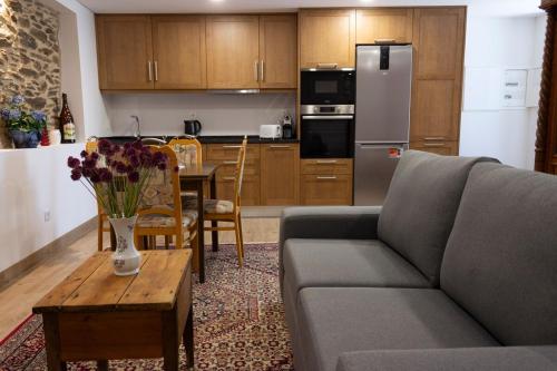 ein Wohnzimmer mit Couch und Tisch und eine Küche in der Unterkunft Casa da Zurja in Guarda