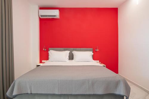 a bedroom with a red wall and a bed at BLUE HORIZON SARTI Oe in Sarti