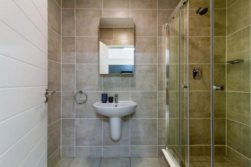 a bathroom with a sink and a shower at #AlimamaSpaces Rob's GreenPark in Boksburg