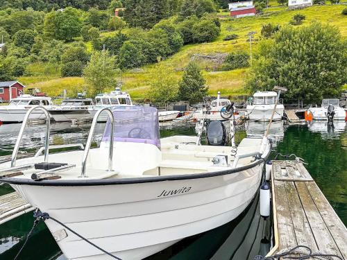 a white boat is docked at a dock at 8 person holiday home in Barmen in Barmen