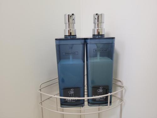 two bottles of water are sitting on a glass shelf at Liberty Shinjuku House in Tokyo