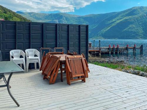 a wooden deck with a table and chairs and a body of water at 8 person holiday home in Barmen in Barmen