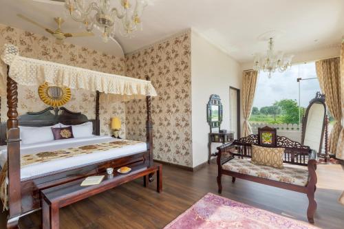 a bedroom with a bed and a chair in it at SaffronStays Raj Reverie in Jaipur