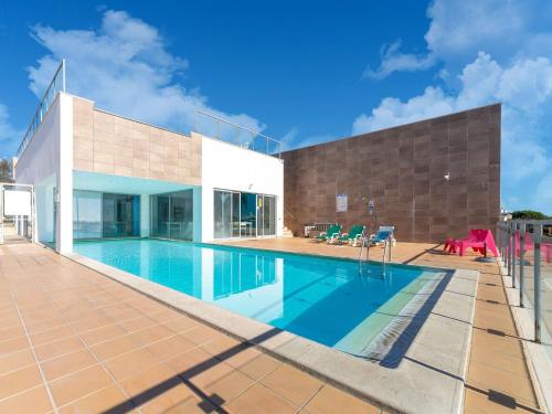 a swimming pool in front of a house at An Idyllic Algarve Home by the Water in Fuzeta