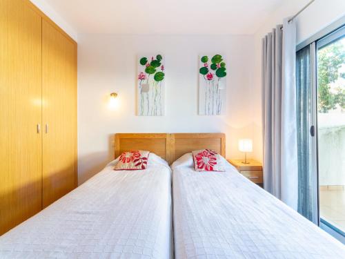two beds in a bedroom with flowers on the wall at An Idyllic Algarve Home by the Water in Fuzeta