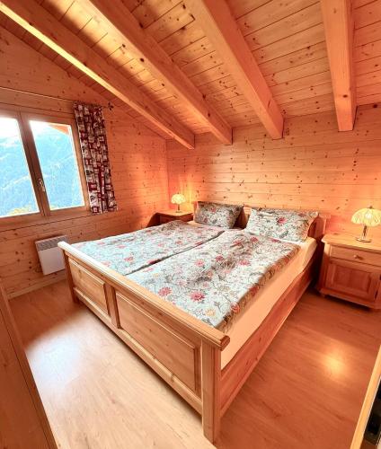 a bedroom with a large bed in a cabin at Chalet Poiema in Bellwald