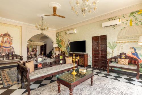 a living room with a couch and a tv at SaffronStays Raj Reverie in Jaipur