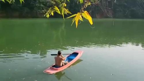 a man sitting on a pink kayak in the water at Lake View Resort in Ban Nam Rop