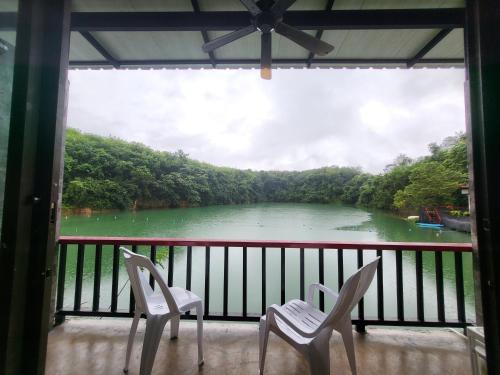 two chairs on a balcony with a view of a river at Lake View Resort in Ban Nam Rop