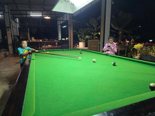 two children playing with a pool table at Lake View Resort in Ban Nam Rop