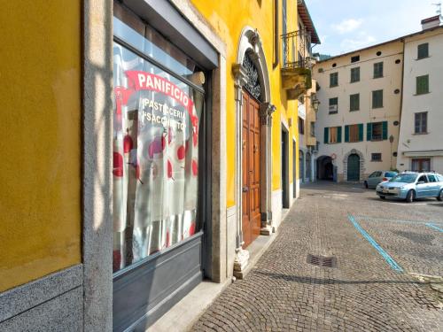 a street in a city with a store window at Wonderful flat with swimming pool, lift and garden in Gravedona