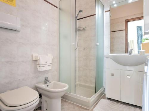a bathroom with a toilet and a sink and a shower at Wonderful flat with swimming pool, lift and garden in Gravedona