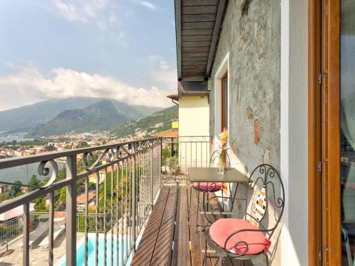 a balcony with a table and chairs and a view at Wonderful flat with swimming pool, lift and garden in Gravedona